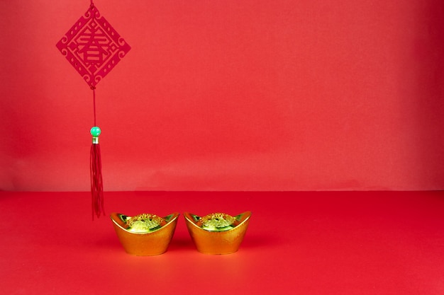 Decorazione di capodanno cinese su uno sfondo rosso bandiera di buona fortuna e grumo d'oro