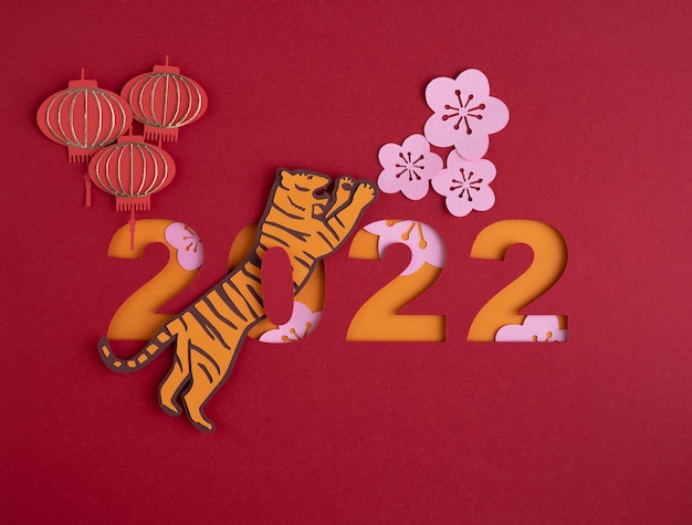 Chinese New Year. Decoration with traditional Chinese New Year motifs, cut paper decorations on red background. Copy space.