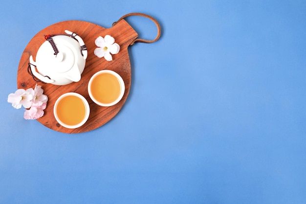 Chinese new year festival decoration with tea set on wooden tray and blossoms Top view