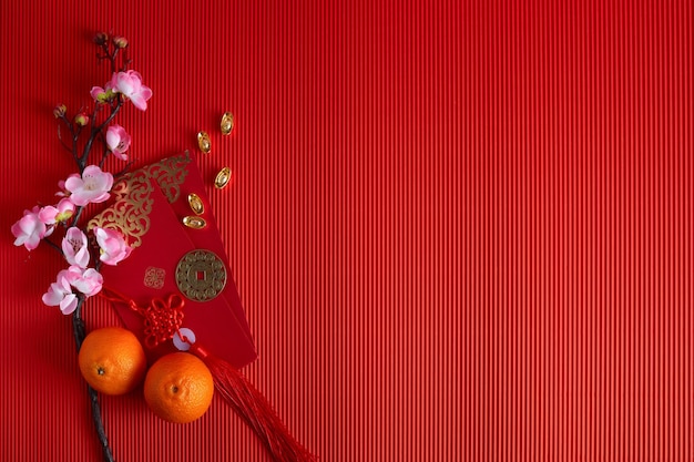 Chinese new year festival decorations orange leaf red packet plum blossom on red background