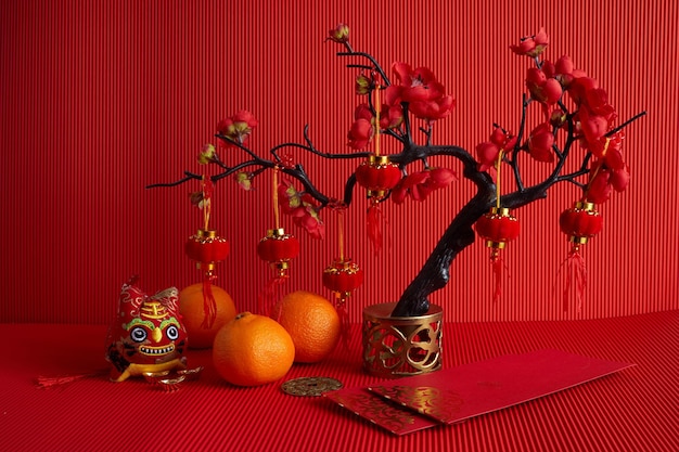 Chinese new year festival decorations orange leaf red packet plum blossom on red background