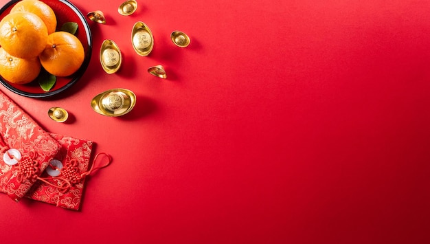 Chinese nieuwjaarsversieringen gemaakt van rood pakket oranje en goudstaven of gouden klomp op een rode achtergrond Chinese karakters FU in het artikel verwijzen naar fortuin, geluk, rijkdom, geldstroom