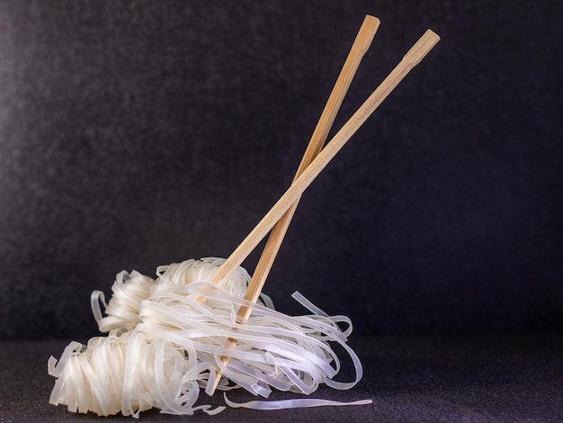 Photo chinese noodles with chopsticks on black background