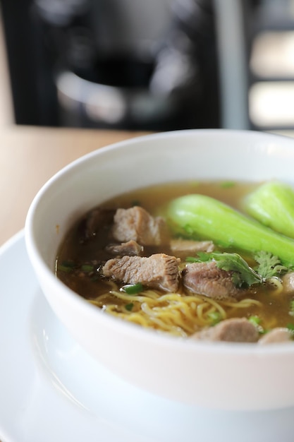 木の背景に豚肉と中華麺