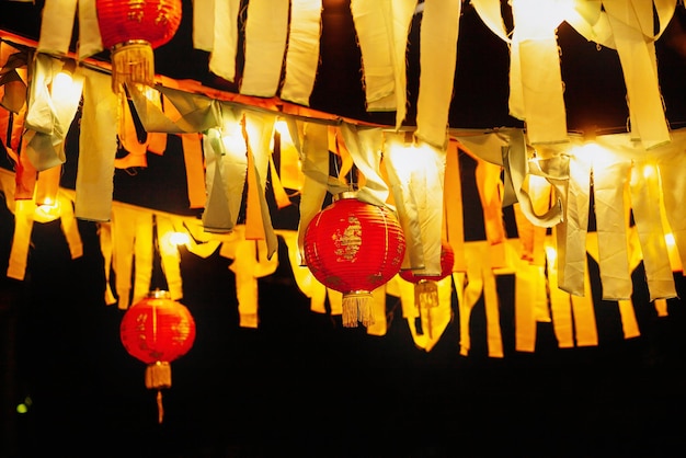 중국 종이 빨간 등불은 마당에서 밤에 리본과 램프의 화환으로 매달려 있습니다