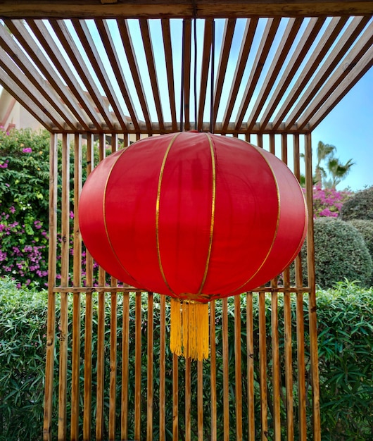 Chinese rode lamp of lantaarn die op het houten terras van het restaurant of café hangt. Nieuwjaarsdecoratie in China. Lantaarnfestival viering achtergrond