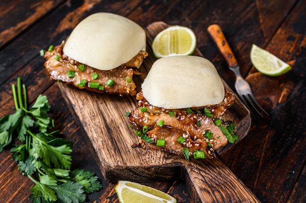 Chinese sandwich steamed gua bao buns with pork. Black background. Top view.