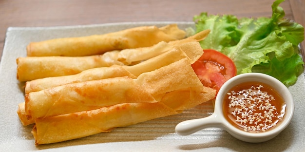 Chinese spring rolls fried with chili sauce and white sesame in a ceramic plate