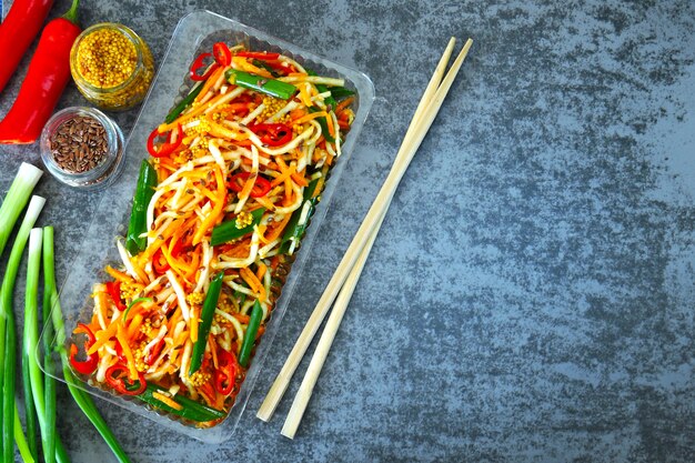 Photo chinese-style salad. fermented carrots, fermented celery root, chili, green onions. salad with fermented vegetables. food sticks.