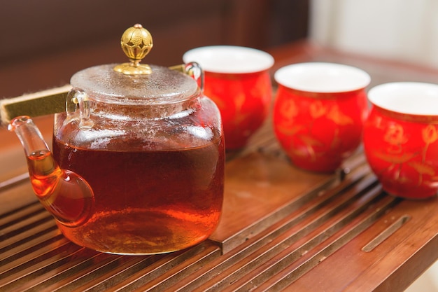 Китайская чайная церемония Керамический чайник из глины и чаши на деревянном фоне