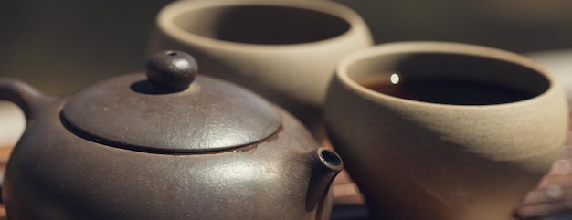 Chinese tea ceremony Ceramic teapot made of clay and bowls on a wooden background