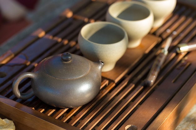 Chinese tea ceremony. Ceramic teapot made of clay and bowls on a wooden background.