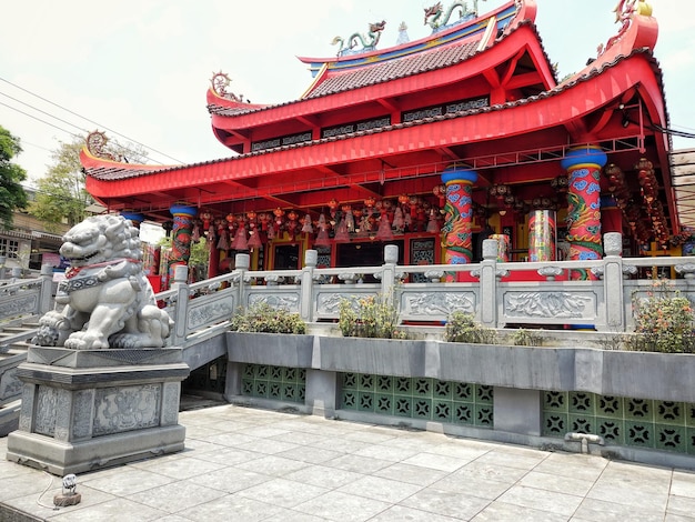 Photo a chinese temple with a statue of a lion on the left side.