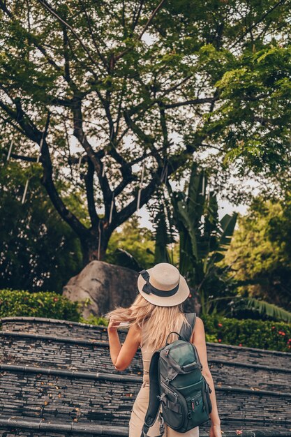 Китайский турист, гуляющий и открывающий природу на отдыхе Азии Кавказская красивая женщина в шляпе с рюкзаком. Концепция путешествия образ жизни. Санья, Хайнань, Китай