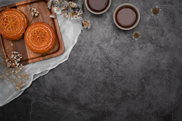 Chinese traditional mid autumn festival moon cake on rustic black background Top view with copy space