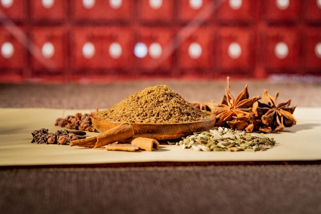 Chinese traditional seasoning five spice powder and raw materials on retro background