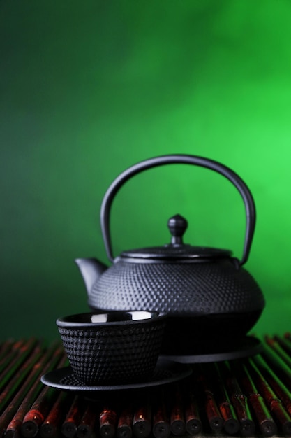 Chinese traditional teapot on bamboo mat on dark color background