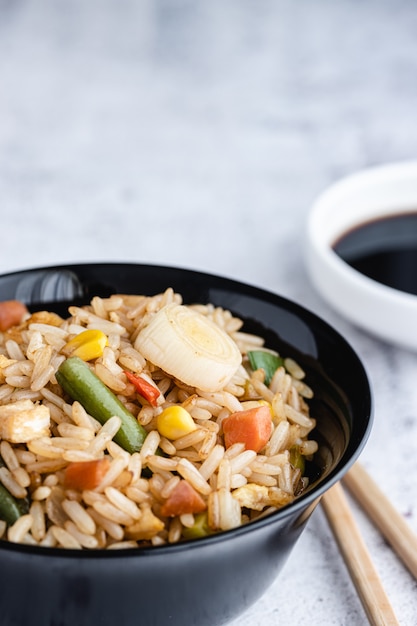 中華野菜チャーハンと卵を箸と醤油で器に盛り付けたもの。中華料理