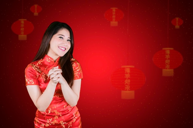 Chinese vrouw staat met een feliciterend gebaar