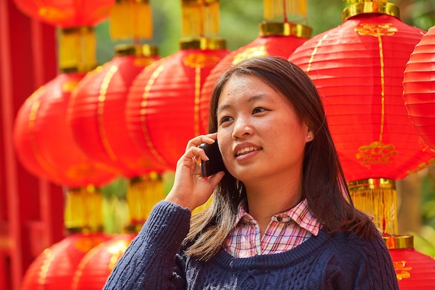 Photo chinese woman talking on cell phone during chinese new year