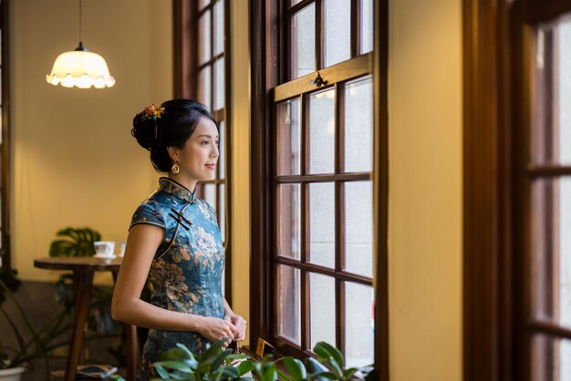 Chinese woman wear cheongsam in traditional house