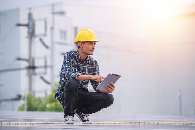 Chinses-ingenieur die zonne-energie controleert op de werkende controle op het fabrieksdak voor industrieel systeem;