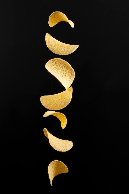 Chips on a black background Flying potato chips