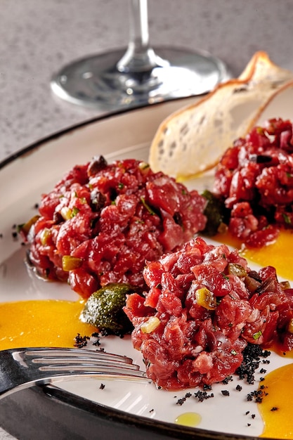 Chips bread with tartare vs carpaccio of beef on table at the restaurant molecular modern cuisine cl