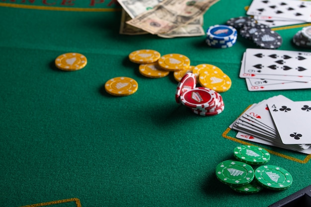 Chips, cards and dollars on a green table 