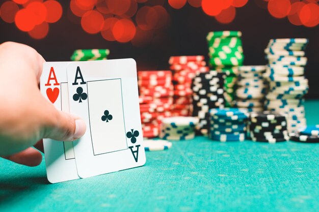 Chips and cards for poker on green table with bokeh