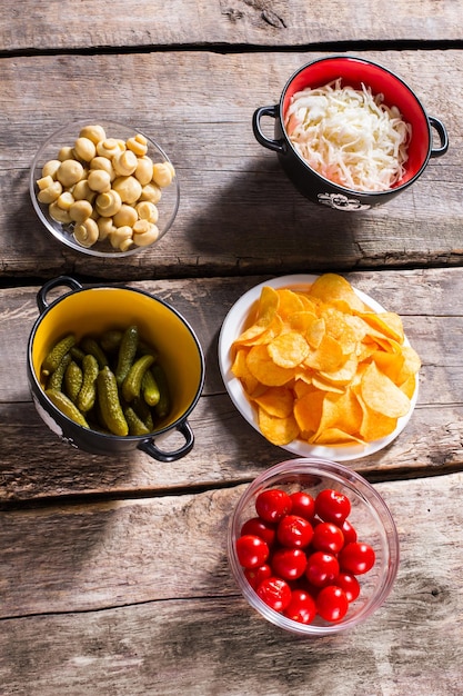 Chips en augurken met zuurkool Pickles en chips op tafel Sappige groenten en aardappelchips Ingrediënten voor smakelijke salade