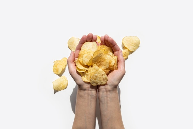 Chips in female palms on a white background Top view flat lay