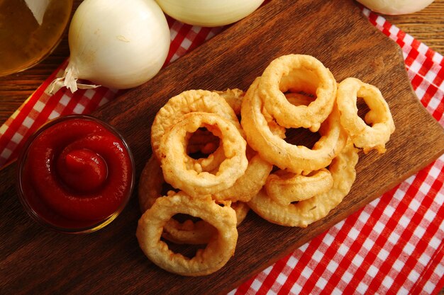 Photo chips rings with sauce and onion on cutting board closeup