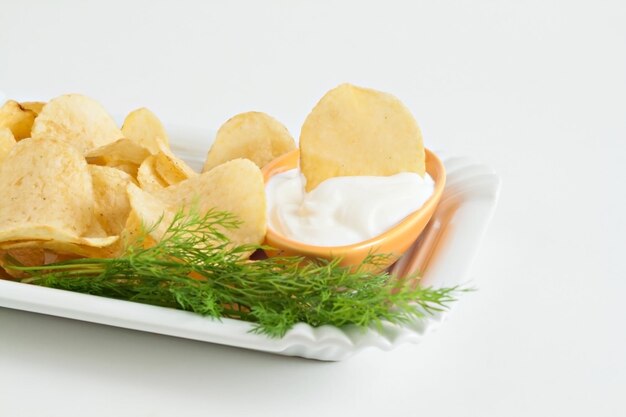 Photo chips with sour cream and dill sauce isolated