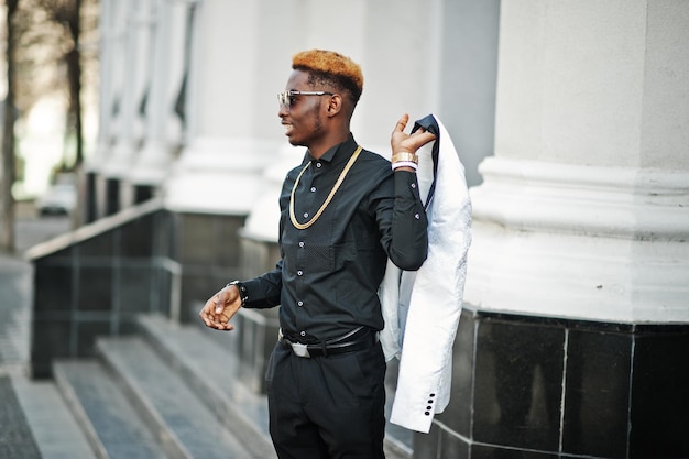 Chique knappe Afro-Amerikaanse man in wit pak en zwart shirt
