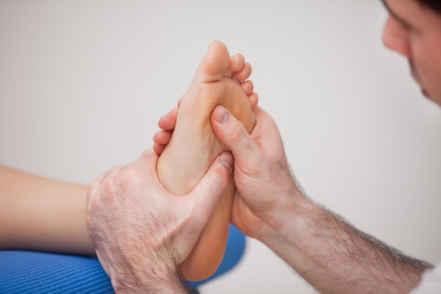 Chiropodist die reflexology op de voet van vrouw uitoefent