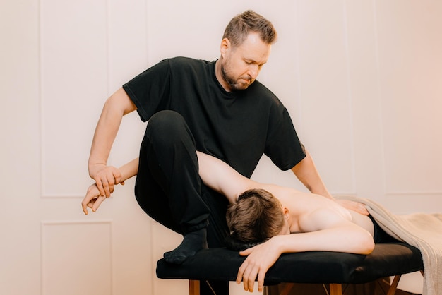 Chiropractic osteopathy manual therapy therapist doing healing treatment on mans back alternative