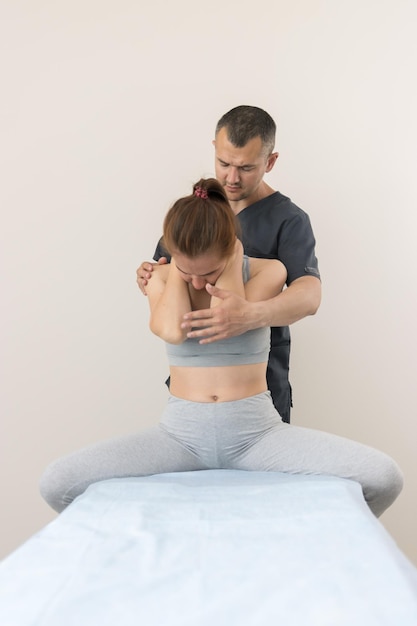 Chiropractische behandeling jonge vrouw zittend op de bepaalde pose die haar nek vasthoudt