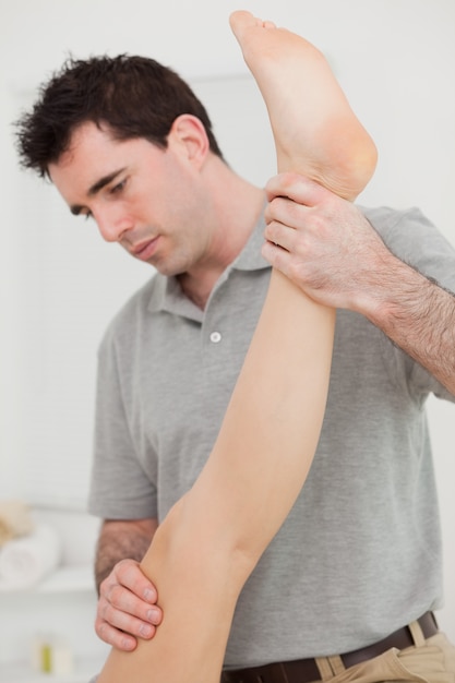chiropractor extending the leg of a patient