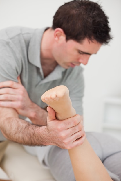 Chiropractor massaging a patient with his elbow in a room