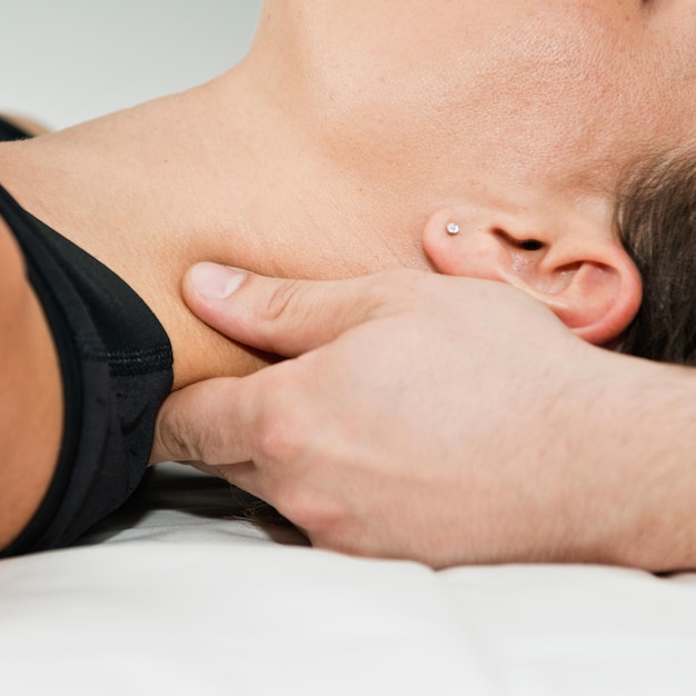 Chiropractor onderzoekt de nek van de patiënt