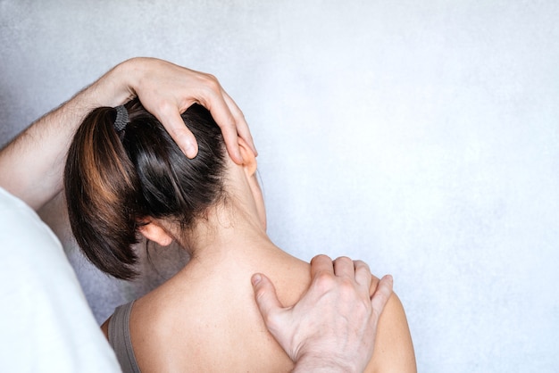 A chiropractor performing a manipulation on woman's neck and administering of spinal adjustments to relive neck pain