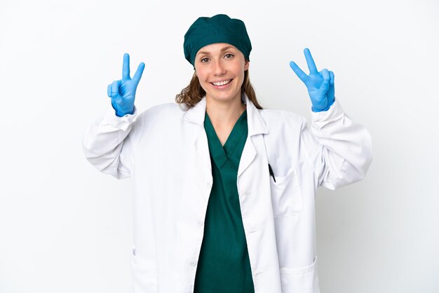 Chirurg blanke vrouw in groen uniform geïsoleerd op een witte achtergrond met overwinningsteken met beide handen