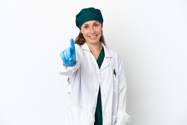 Chirurg blanke vrouw in groen uniform geïsoleerd op een witte achtergrond, tonen en optillen van een vinger