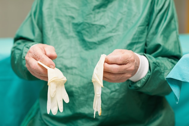 Foto chirurg die chirurgische handschoenen houdt