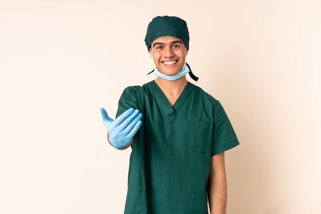 Chirurg man in blauw uniform over geïsoleerde uitnodigen om te komen
