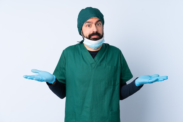 Chirurg man in groen uniform over muur twijfels gebaar maken