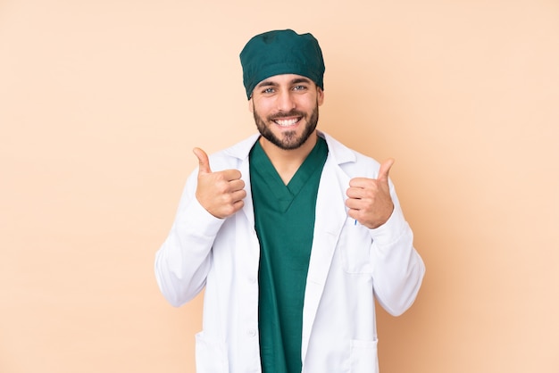 Chirurg man op beige muur geven een duim omhoog gebaar