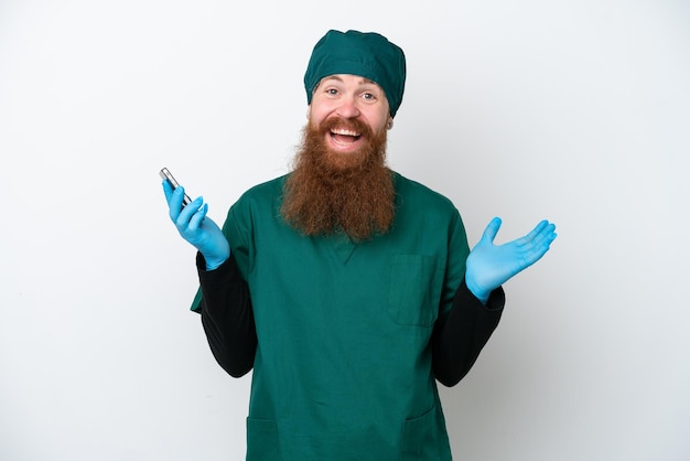 Chirurg roodharige man in groen uniform geïsoleerd op een witte achtergrond een gesprek voeren met de mobiele telefoon met iemand