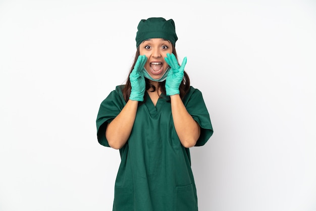 Chirurg vrouw in groen uniform op wit schreeuwen en iets aankondigen